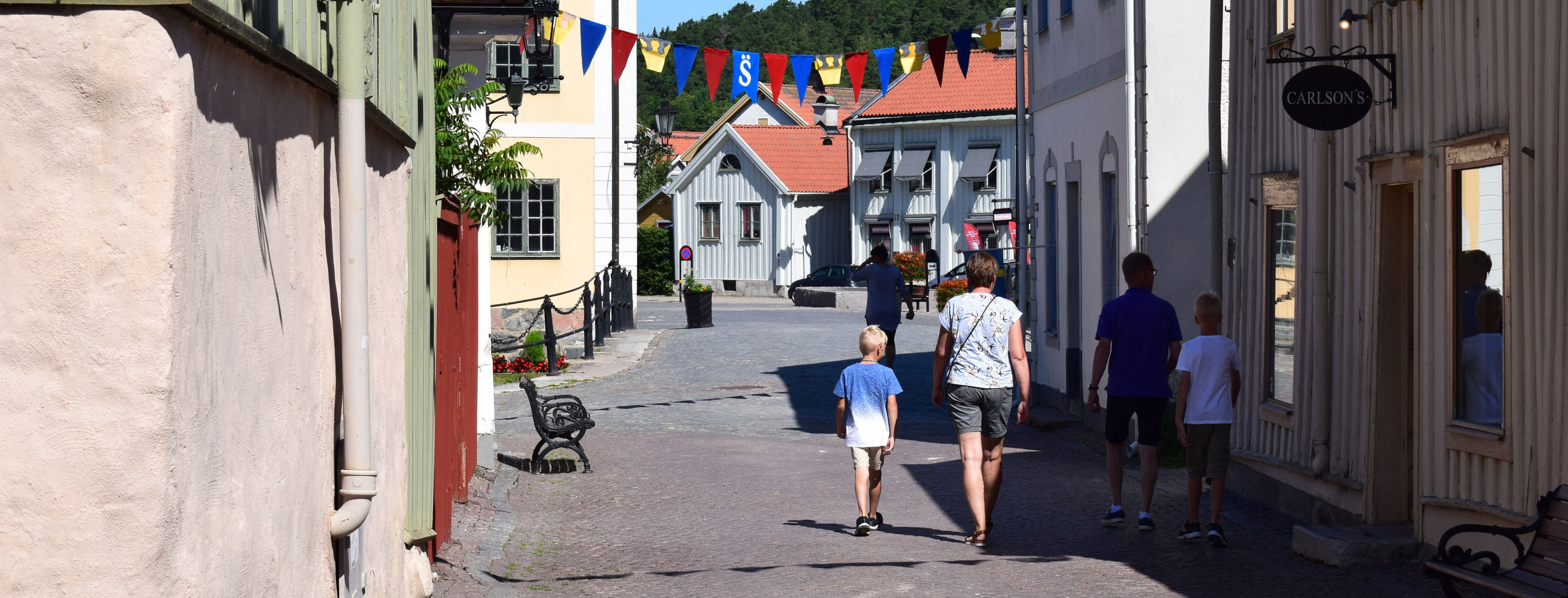Bild visar en familj som går längs affärsgata i Söderköping